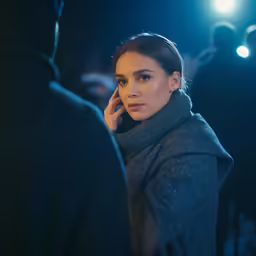 a young woman wearing a scarf and looking around