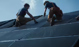 a couple of men that are on the roof of a building