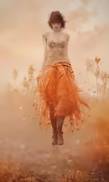 a young woman is jumping into the air and wearing an orange dress