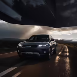 a grey range rover car driving down an open road