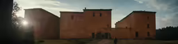 the sun shines on a two building brick castle