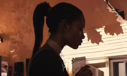 a young woman with long ponytail standing in front of an unfinished ceiling