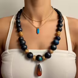 a beautiful young lady with a multi colored bead necklace,a woman wears a necklace with a stone drop,a necklace made up of various items on a woman