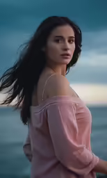 a woman looking off into the distance with a cloudy sky in the background