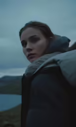 a woman with blue eyes looks away from the camera