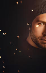 a man with a dark background holds a yellow circle in the darkness