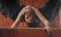 a girl in black dress holding her hands on her face