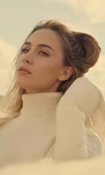 a woman with long hair is posing on a beach