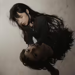 two people with black hair are facing away