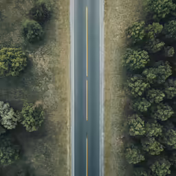 an overhead view of an empty highway that appears to be in the middle of nowhere