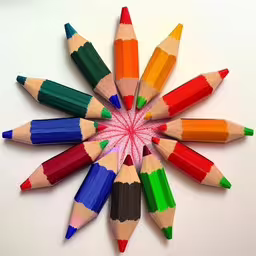 multiple colored pencils arranged in a star shape,a group of colored pencils arranged in the shape of a star