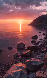 the sun is rising over a beach near water
