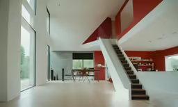 a large room with lots of windows and a staircase leading to the second floor