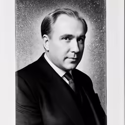 a black and white portrait of a man in a suit and tie