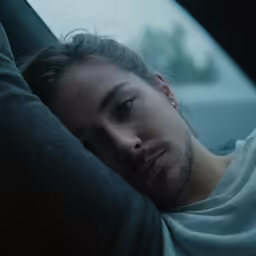 a man with his head up in the back seat of a car