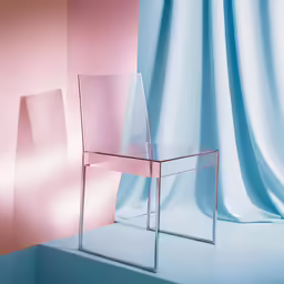 the clear chair is in front of a pink wall