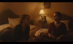 two women are on a bed in the room