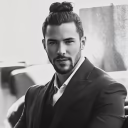 a man in a suit and tie sitting on a chair