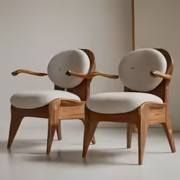 the two chairs have a rounded back and armrests