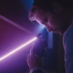 man holding camera under lights on stage and making a light beam