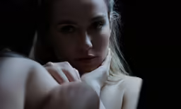 a close up of a women with a black background
