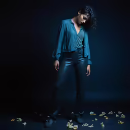 a woman is standing with flowers on a black background