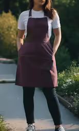 a women in a maroon apron standing on a sidewalk