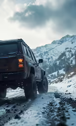 a black jeep driving through the snow on a snowy road