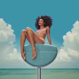 a woman sitting on a blue surfboard over the ocean
