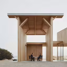 people are seated at a small table underneath a structure