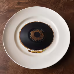 a white plate topped with a round black saucer
