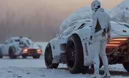a person in white near a snow covered car