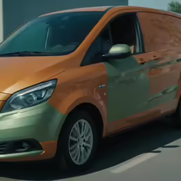 a orange colored van parked on the side of a street