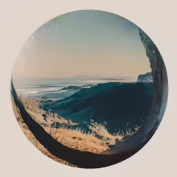 the panorama is of an ocean with land in the background