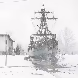 a boat sitting in the snow with wires on it