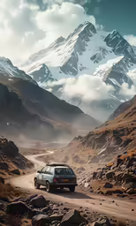 a car drives down a dirt road with snowy mountains in the background