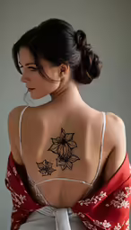 a woman in white dress with tattoos on her back