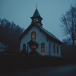 a church with a steeple and a clock tower sits next to a street