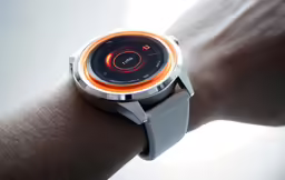 a person wearing an orange and silver watch