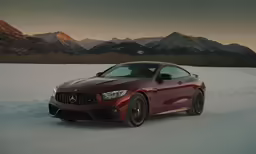 the mercedes amg coupe is driving in the snow