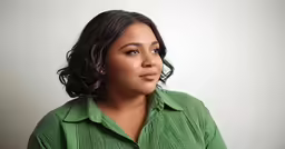 a woman looking away while wearing a green shirt