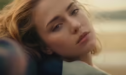 a woman looks into the distance while wearing a black top