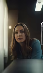 a woman staring at the camera in a room with lights on