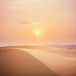 the sun is setting over the dunes in the desert