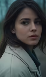 a woman wearing a jacket stares to the side