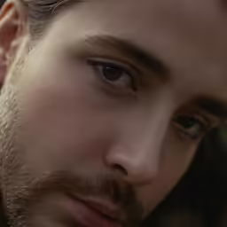 a close up photo of a man with long hair and a beard