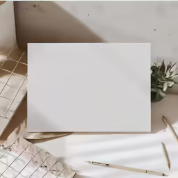 the photo shows a square frame, pencils and a pen