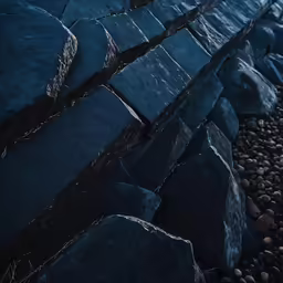 a stone wall in a beach area near water