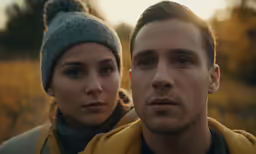 a couple dressed warm wearing scarves in the middle of winter