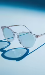 two clear sunglasses sitting on top of a white table